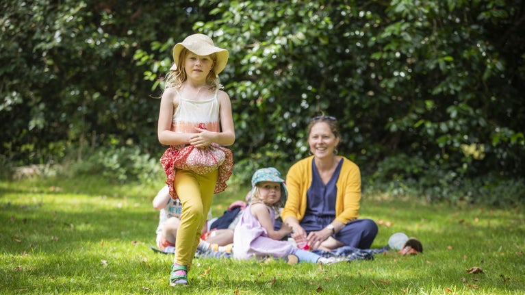 Adult and children having a picnic on a grassy meadow